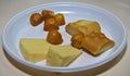 Assortment of Polish cheese on a white plate: Tilsit or TylÃÂ¼ycki, GoÃâka or Gouka and Oscypek cheeses sliced and ready for a